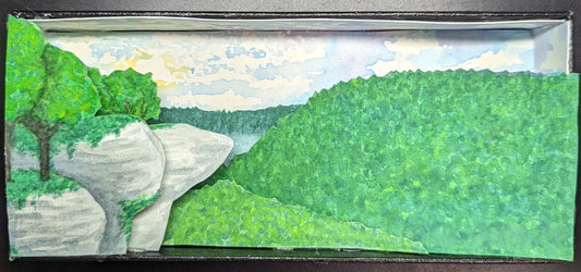 Layers of the Ozark Mountains painted onto paper, cut out, and pasted onto a box to mimic a shadowbox